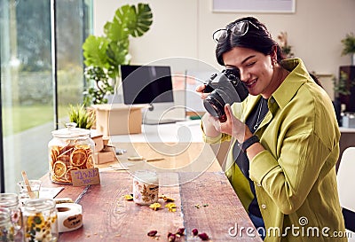 Woman Running Online Business Making Boutique Candles Taking Photos For Online Marketing Stock Photo