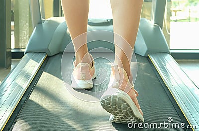 Woman running on treadmill in the gym which runner athletic by running shoes. on white background Health and sport Stock Photo