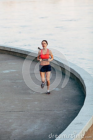 Woman runnning along granite curved parapet Stock Photo