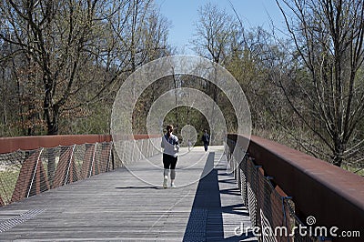 A Woman runs over the Wolf River Bridge Editorial Stock Photo