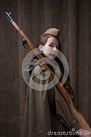 Woman in Russian military uniform with rifle. Female soldier during the second world war. Stock Photo