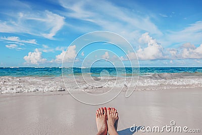 Woman`s feet on the tropical Caribbean beach. Ocean and blue sky Stock Photo