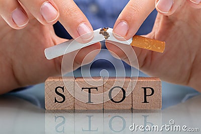 Woman Breaking Cigarette Over Stop Wooden Blocks Stock Photo