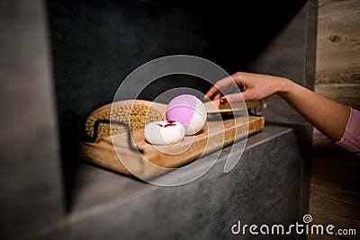 Woman`s hand carefully takes bath brush from shelf in the bathroom. Stock Photo
