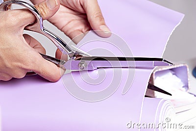 Woman`s hand cutting purple fabric Stock Photo