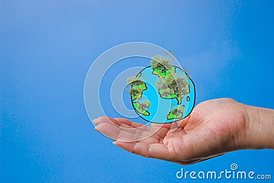 A woman`s hand with a globe created from a painting with a tree in the forest. Stock Photo