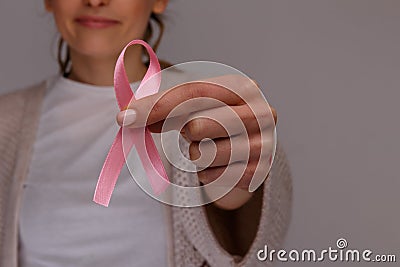 Woman`s hand holding pink ribbon . Stock Photo