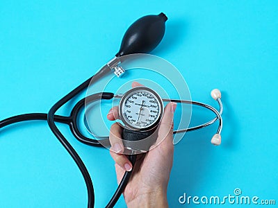 A woman`s hand holds a blood pressure monitor that shows blood pressure Stock Photo