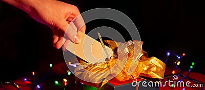 A woman& x27;s hand holds a label on a gift box. Stock Photo