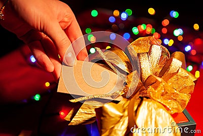 A woman& x27;s hand holds a label on a gift box. Stock Photo