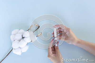 Womanâ€™s hand holds a sanitary tampon Stock Photo