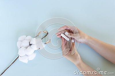 Womanâ€™s hand holds a sanitary tampon with the cotton Stock Photo