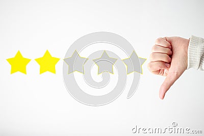 Woman`s hand holds thumb down and stars, a concept low ranking Stock Photo
