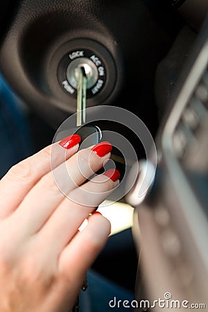 A woman`s hand inserts the ignition key into the lock. Stock Photo