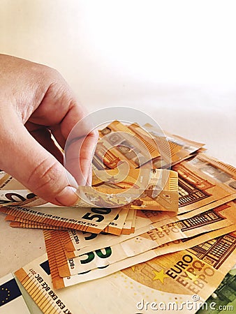 Hand and pile of â‚¬50 banknotes Stock Photo