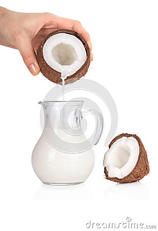 Woman's hand pouring coconut milk into a jar on white Stock Photo