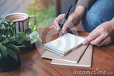 A woman`s hand preparing to write on blank notebook Stock Photo