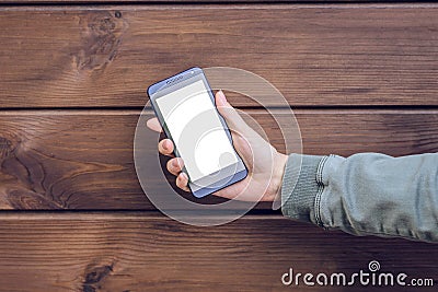 Woman`s hand showing empty blank touchscreen on her mobile phone against brown wooden planks cell phone cellphone telephone mobil Stock Photo