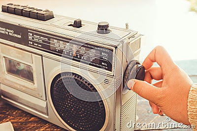 Woman`s hand switched and adjusting button cassette player and recorder for listen music Stock Photo