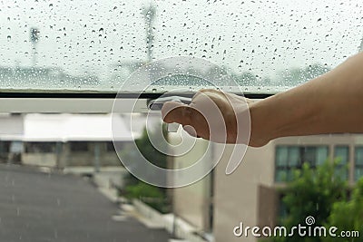 The woman`s hand was closing the window because of the rain Stock Photo