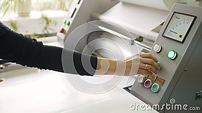 Woman`s hand at working printing machine, polygraph industry Stock Photo