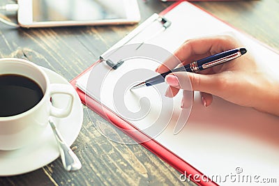 Woman`s hand writing on a blank planner at cafe Stock Photo