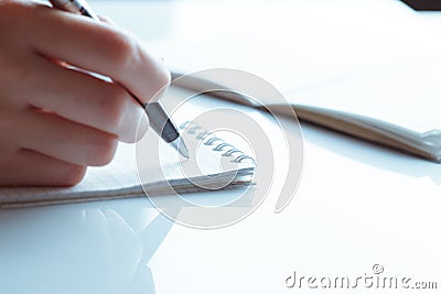 Woman's hand writing entries in a notebook Stock Photo