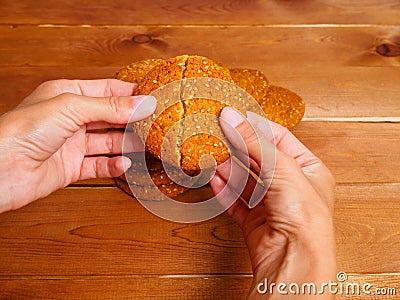 Woman's hands breaking oatmeal cookies Stock Photo