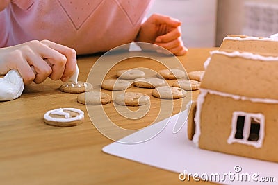 Woman`s hands decorate christmas cookies with sugar sweet icing. Stock Photo