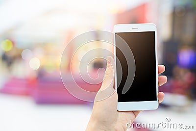 Woman`s hands holds modern electronic gadget. Unrecognizable female with white mobile phone and blank black screen for your advert Stock Photo