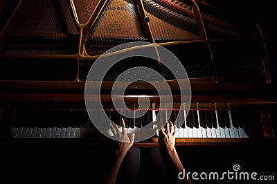 Woman's hands on the keyboard of the piano in night closeup Stock Photo