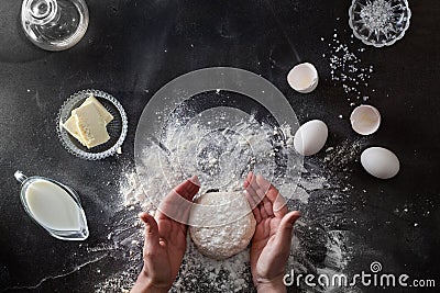 Woman's hands knead dough on table with flour Stock Photo