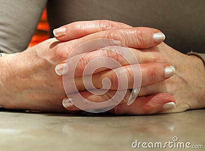 Woman's Hands linked on table Stock Photo