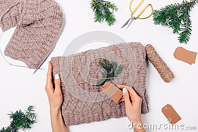Woman's hands packing knitted wool sweater Stock Photo