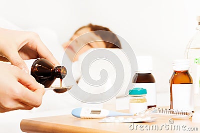 Woman`s hands pouring antipyretic syrup for kid Stock Photo