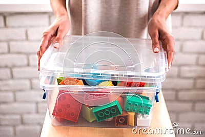 Woman`s hands putting colored blocks into box. Stock Photo