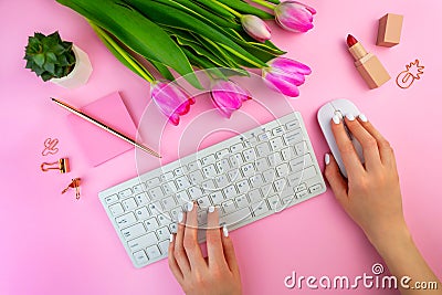 Woman`s hands typing on the keyboard. Feminine work space on pink flat lay. Remote distant home office, freelance, distance Stock Photo