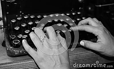 Woman`s hands writing on a vintage typewriter. Hands writing on old typewriter black and white photo Stock Photo