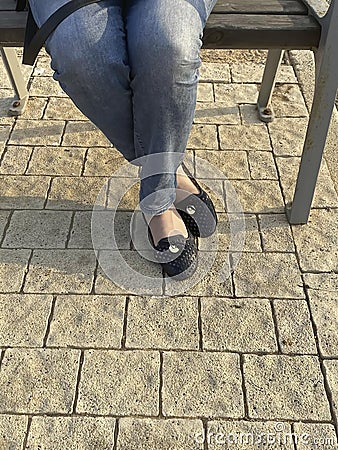 Woman`s legs in blue jeans and black pumps shoes Stock Photo