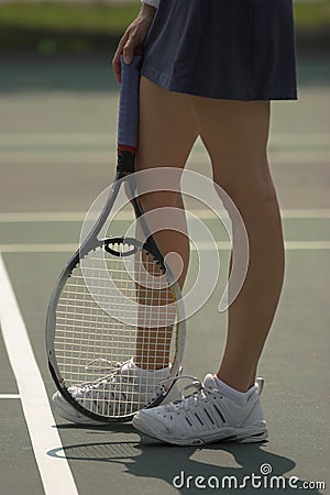 Woman's legs on tennis court Stock Photo