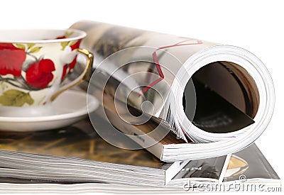 Woman's rolled glossy magazine in stack Stock Photo