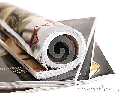 Woman's rolled glossy magazine in stack. Stock Photo