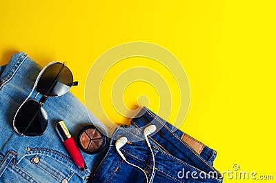 Woman`s Things Elegant Accessories . Jeans lipstick glasses headphones. place for text yellow background summer Stock Photo