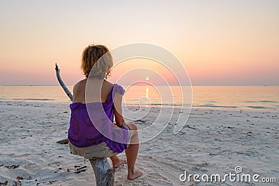 Woman on sand beach romantic sky at sunset, rear view silhouette, golden sunlight, real people. Indonesia, Kei islands, Moluccas Stock Photo