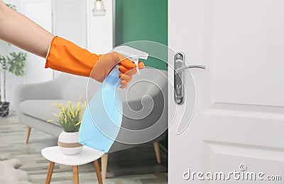 Woman sanitizing door handle with antiseptic spray. Be safety during coronavirus outbreak Stock Photo