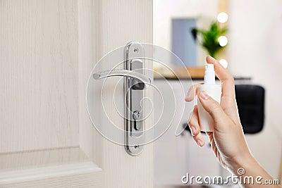 Woman sanitizing door handle with antiseptic spray. Be safety during coronavirus outbreak Stock Photo