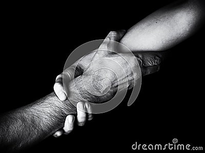 Woman saving, rescuing and helping man by holding or griping the forearm. Female hand and arm pulling up male. Stock Photo