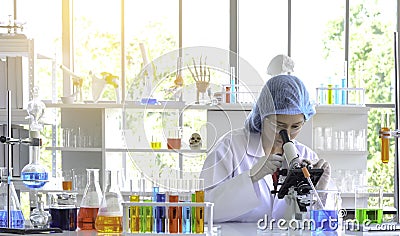 Woman scientist doing experiment with Microscope. Stock Photo