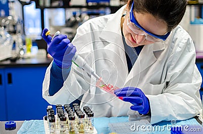 Woman scientist performing biomedical research in laboratory Stock Photo