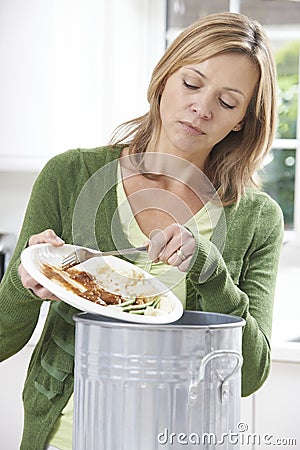 Woman Scraping Food Leftovers Into Garbage Bin Stock Photo
